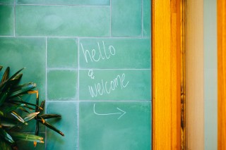 Door frame with welcome note written on wall.